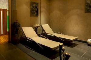 Relaxationsraum im Doubletree by Hilton Istanbul Moda mit zwei Liegen, einem Tisch und weichen Kerzen auf den Tisch.