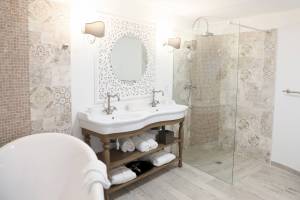 Badezimmer im L'Hostellerie du Moulin mit Badewanne, Waschbecken und Dusche