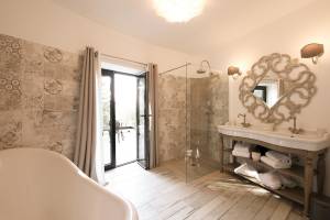 Badezimmer mit Badewanne, Dusche, Waschbecken und Holzboden, L'Hostellerie du Moulin