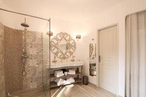 Badezimmer im L'Hostellerie du Moulin mit begehbarer Dusche, zwei Waschbecken und Spiegel.