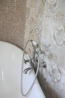 Ein Badezimmer mit einer weißen Badewanne und modernen Armaturen.