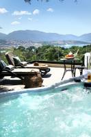 Außenbereich mit Blick auf das Meer, Lounge-Liegesesseln und einem Whirlpool.
