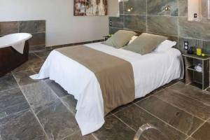 Schlafzimmer im Hotel La Lagune mit einem großen Bett und Badewanne