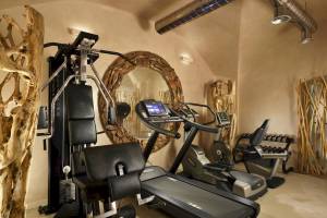 Fitnessraum mit Laufband und Gewichten im Leon's Place Hotel.