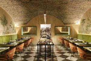 Innenbereich des Restaurants Leon's Place mit gemustertem Boden und runden Tischen.