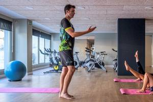 Ein Trainer zeigt eine Yoga-Übung in einem Fitnessstudio des ARTIEM Audax Hotels.