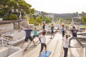 Yoga Kurs auf der Dachterrasse des ARTIEM Audax Hotels mit Teilnehmern und Blick auf die Landschaft