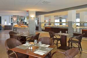Innenbereich des Restaurants im Sol Milanos Pinguinos Hotel mit Tischen, Stühlen und Essensbereich