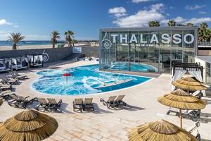 Außenbereich des Barcelo Fuerteventura Castillo mit Pool und Sonnenliegen am Strand.