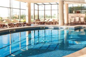 Innenpool des Punta Prima Resort & Spa mit Lounge-Sesseln und Glaswänden