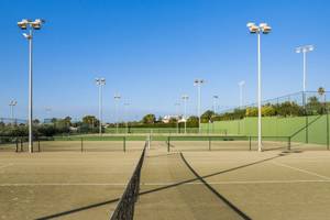 Tennisplatz im Punta Prima Resort & Spa mit leeren Feldern und Sonnenschein