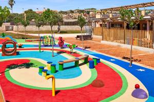Kinderspielplatz im Freien mit bunten Spielgeräten und Bäumen, Punta Prima Resort & Spa