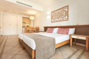Schlafzimmer im Punta Prima Resort & Spa mit Doppelbett, Dekor und Esstisch im Hintergrund.