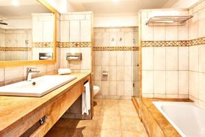 Badezimmer im Punta Prima Resort & Spa mit Waschbecken, Spiegel und Dusche