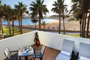 Aussicht vom Balkon im Barcelo Fuerteventura Castillo Hotel auf eine Strandpromenade mit Palmen und Meer.