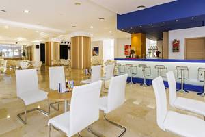 Lobby des Globales Lord Nelson Hotels mit weißen Stühlen und einer Theke