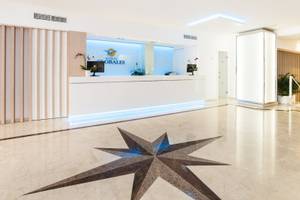 Empfangsbereich des Globales Lord Nelson Hotels mit Logo, Sternenmuster im Boden und modernen Möbeln