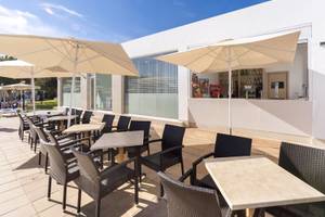 Terrasse des Globales Lord Nelson Hotels mit Tischen und Stühlen unter Sonnenschirmen
