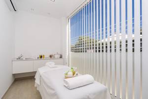 Massageraum im Globales Lord Nelson Hotel mit Behandlungstisch und Blick nach draußen