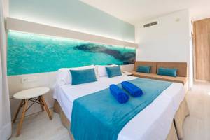 Hotelzimmer im Globales Lord Nelson mit großem Bett, blauem Dekor und Wandbild.