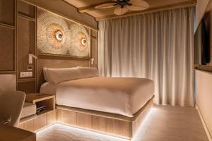 Schlafzimmer im Lago Resort Menorca mit einem Bett, Holzwänden und modernen Leuchten.