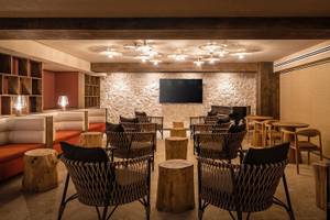 Loungebereich im Lago Resort Menorca - Suites del Lago mit Möbeln und einer Fernsehwand