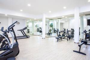Fitnesscenter im Grupotel Playa Club mit Laufband, Hantelbank und anderen Geräten