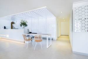 Empfangsbereich des Carema Beach Menorca Hotels mit weißem Schreibtisch und Stühlen.