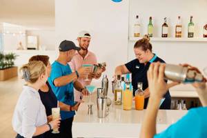 Gäste lernen am Cocktailstand im Hotel Victoria Menorca Cocktails zuzubereiten
