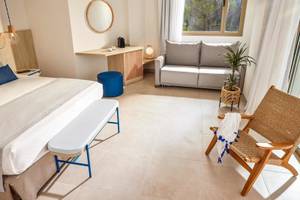 Victoria Menorca Hotelzimmer mit Doppelbett, Couch, Tisch und Fenster.