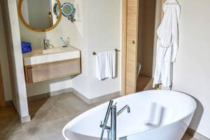 Badezimmer im Victoria Menorca Hotel mit Badewanne, Waschbecken und Spiegeln.