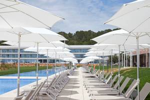 Poolbereich im Seth 55 Santo Tomás mit Sonnenschirmen und Liegestühlen.