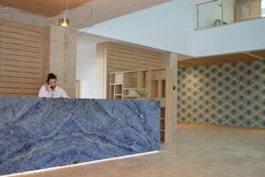 Rezeption des Seth 55 Santo Tomás Hotels mit marmorner Theke und blauem Hintergrund