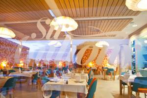 Innenansicht des Restaurants Seth 55 Santo Tomás mit blauen und orangefarbenen Stühlen und Tischen.