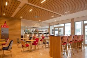 Loungebereich des Seth 55 Santo Tomás Hotels mit Holzelementen, Tischen und Stühlen.