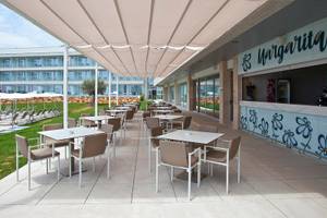 Terrasse des Seth 55 Santo Tomás Hotels mit Tischen, Stühlen und Margarita Bar.
