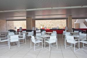 Lounge-Bereich des Seth 55 Santo Tomás Hotels mit weißen Tischen und Stühlen.
