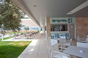 Außenbereich des Seth 55 Santo Tomás Hotels mit der Margarita Bar, Tischen und Stühlen