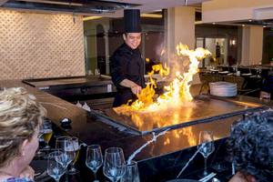 Koch mit Flammen auf Grill im Restaurant des Senator Puerto Plata Spa Resorts