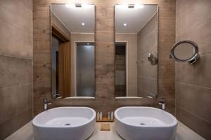 Badezimmer im Miraggio Thermal Spa Resort mit zwei Waschbecken und Spiegeln