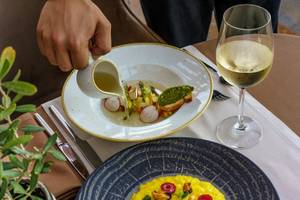 Essen im Miraggio Thermal Spa Resort mit Salat und Weinglas auf einem Tisch.