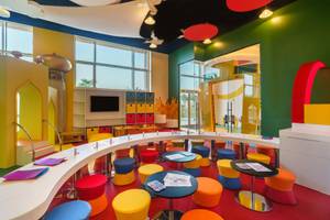 Kinderzimmer im Rixos Marina Abu Dhabi mit bunten Möbeln und einer Tafel.