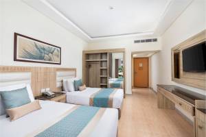 Doppelzimmer im Pickalbatros Aqua Park Resort in Hurghada mit zwei Betten, Kleiderschrank und Fernseher.