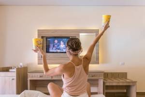Frau auf dem Bett im Hotelzimmer Popcorn trinken