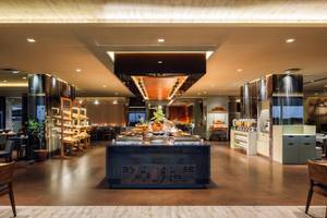 Frühstücksbuffet im Saccharum Hotel mit verschiedenen Gerichten und Sitzbereichen.