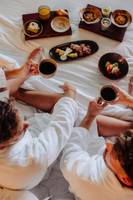 Frühstück im Bett im Saccharum Hotel mit verschiedenen Gerichten und Getränken.