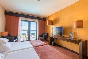 Doppelzimmer im Vila Galé Santa Cruz Hotel mit Meerblick und moderner Einrichtung.