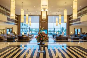 Lobby des Vila Galé Santa Cruz Hotels mit großen Fenstern und modernem Innendesign.