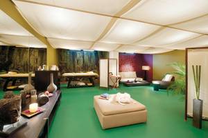 Wellnessbereich des Madeira Panorâmico Hotels mit grünem Boden, Massagetischen und Pflanzen.