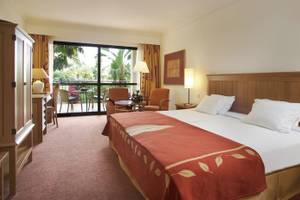 Ein Schlafzimmer im Hotel Porto Mare - PortoBay mit einem Doppelbett, einem Balkon und einem Wohnzimmerbereich.